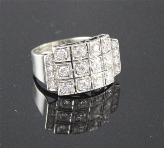 A white metal (stamped 750 and Pt 950) and pave diamond set cocktail ring, of curved design and set with twenty round cut stones.